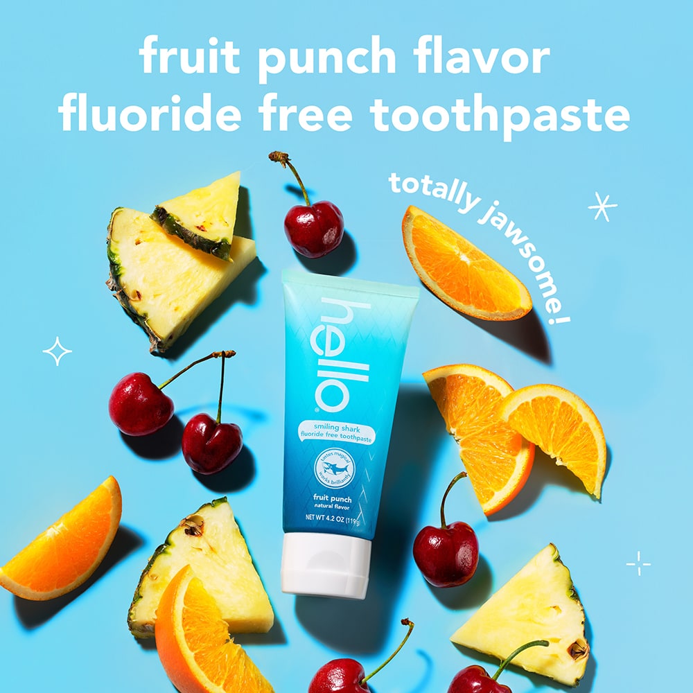 hello Kids Smiling Shark Fluoride Free Toothpaste against a background of fruit. In text: Fruit punch flavor. Fluoride free toothpaste.