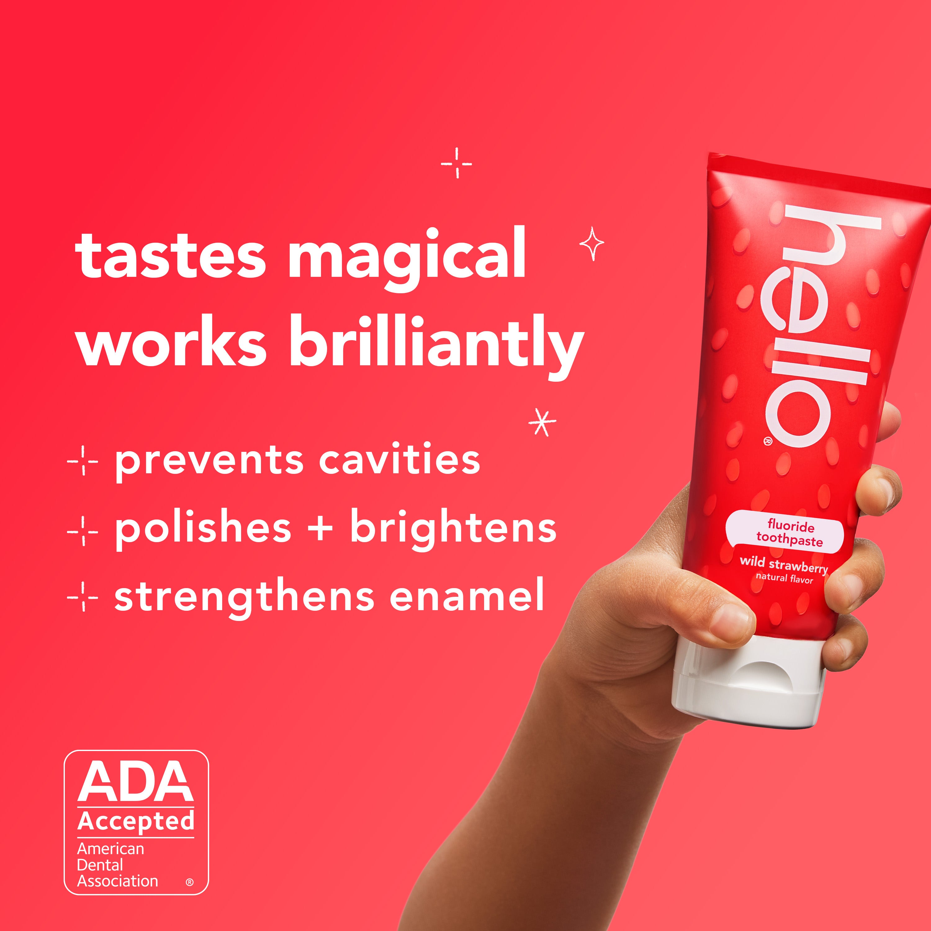 A hand holding a tube of hello kids natural wild strawberry fluoride toothpaste. In text: Tastes magical, works brilliantly. Prevents cavities, polishes + brightens, and strengthens enamel. 